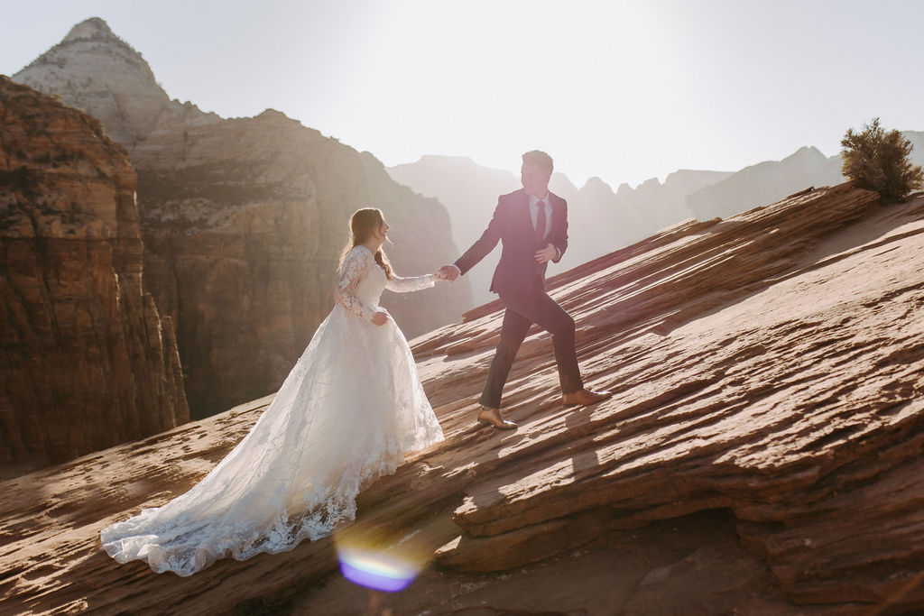 bride and groom hiking at zion canyon overlook on elopement day