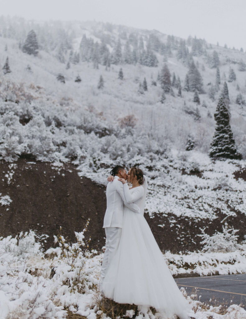 couple kissing in the snowy mountains in utah