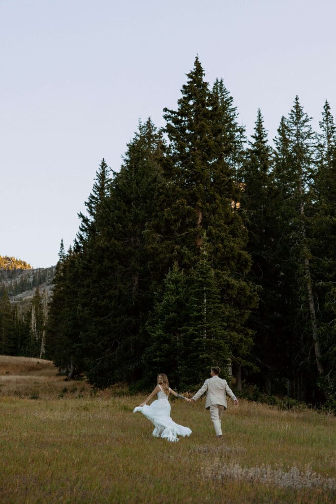 bride and groom run through the trees on elopement day