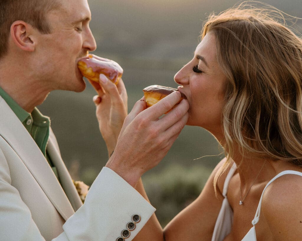 newlyweds share donuts at their mountain elopement