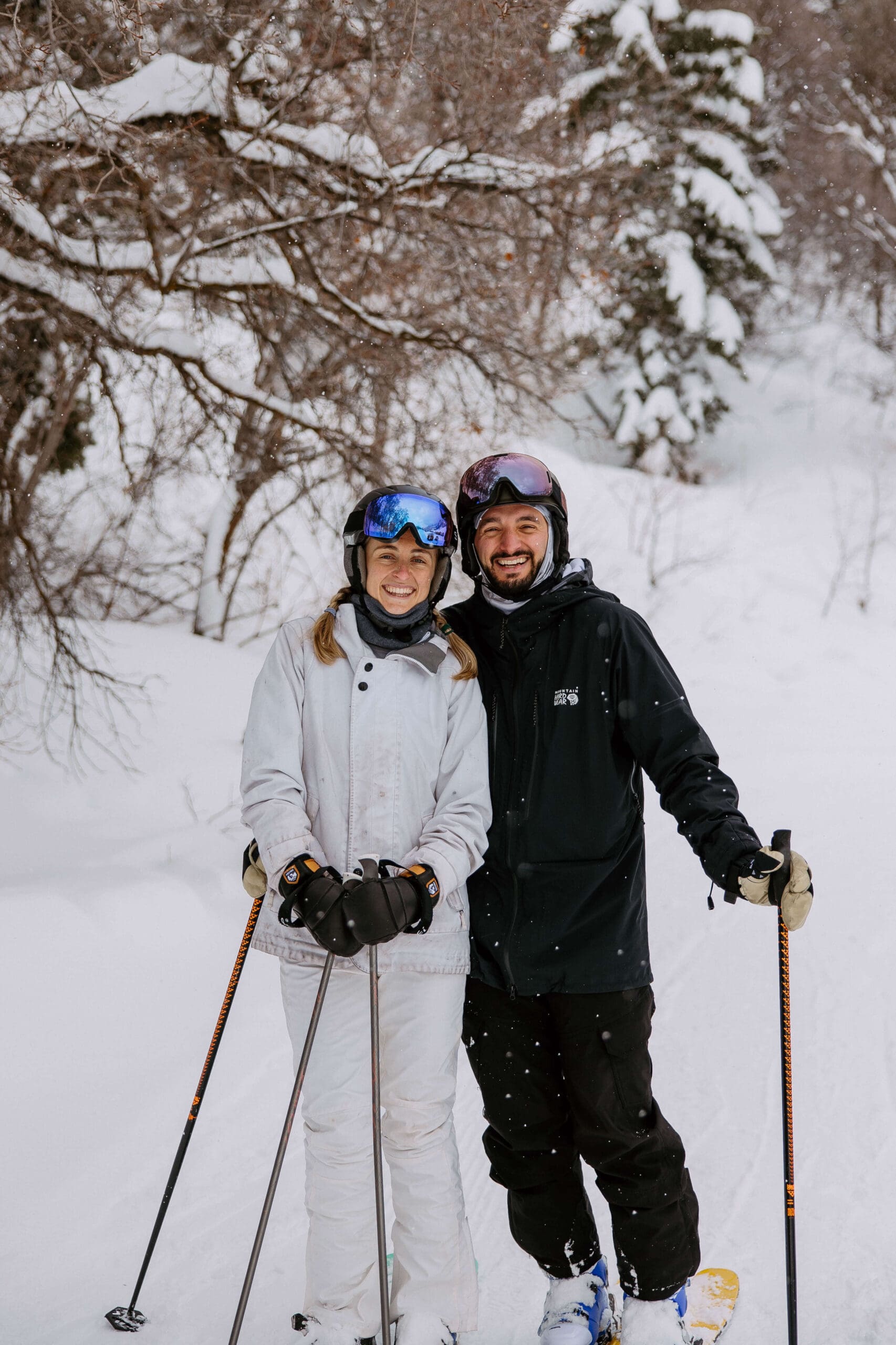 Bride and groom hit the slopes at Snowbasin Ski Resort during their winter elopement, surrounded by snowy pine trees and mountain peaks.