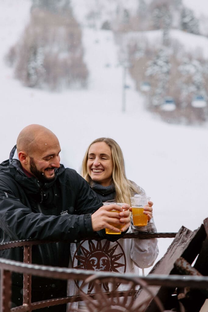 Couple enjoys local craft beers around the fire on their winter elopement day in Utah