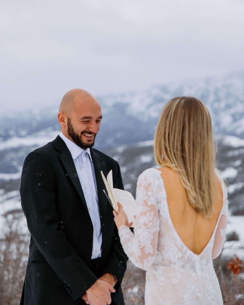 bride and groom read vows at a snowy mountain overlook in ogden, utah