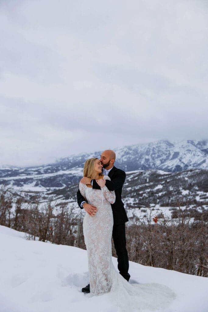 Bride and groom embrace in the Wasatch Mountains during their winter elopement in Ogden, Utah.