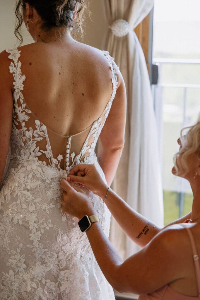 bride putting on wedding dress