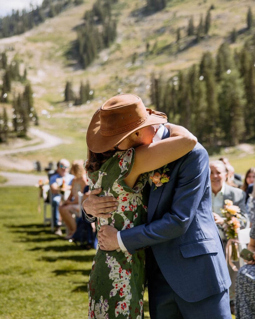 groom hugs mom during wedding ceremony