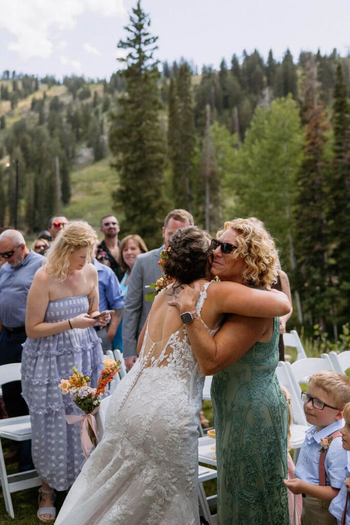 bride hugs mom during wedding ceremony