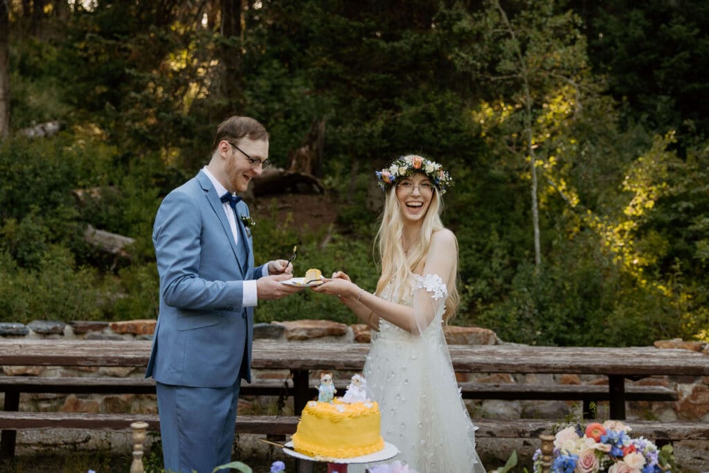 bride and groom cut cake in the mountains