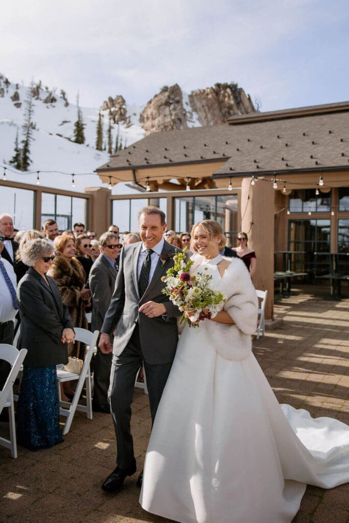 dad walking bride down aisle at snowbasing resort