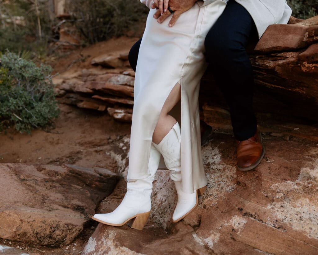 bride and groom silky wedding dress and white cowboy boots in zion national park