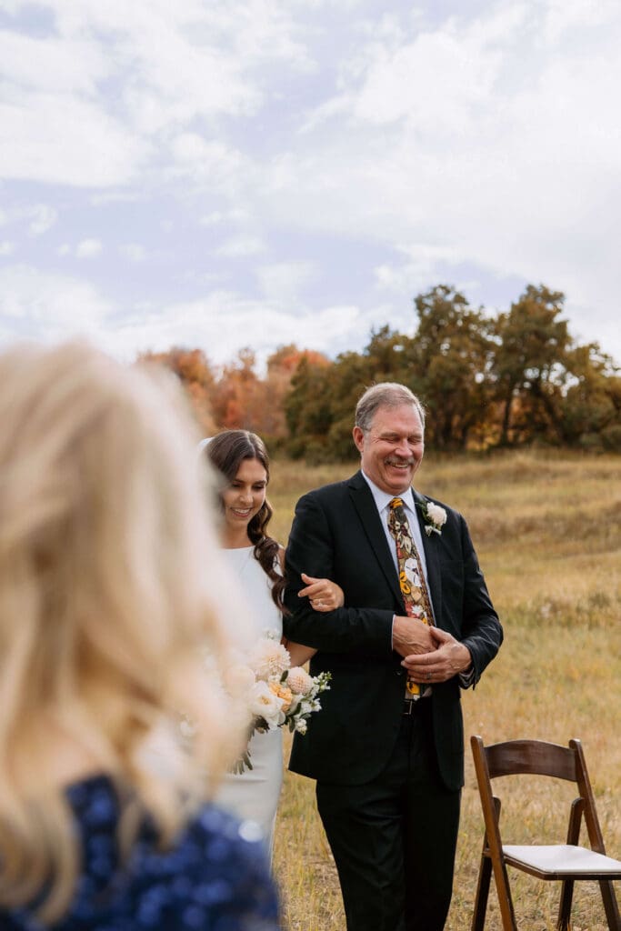 dad walking bride down aisle at outdoor wedding ceremony