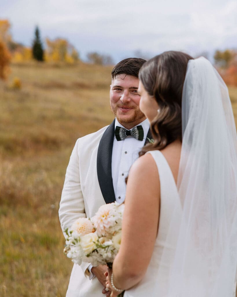 groom looking at bride during outdoor wedding ceremony