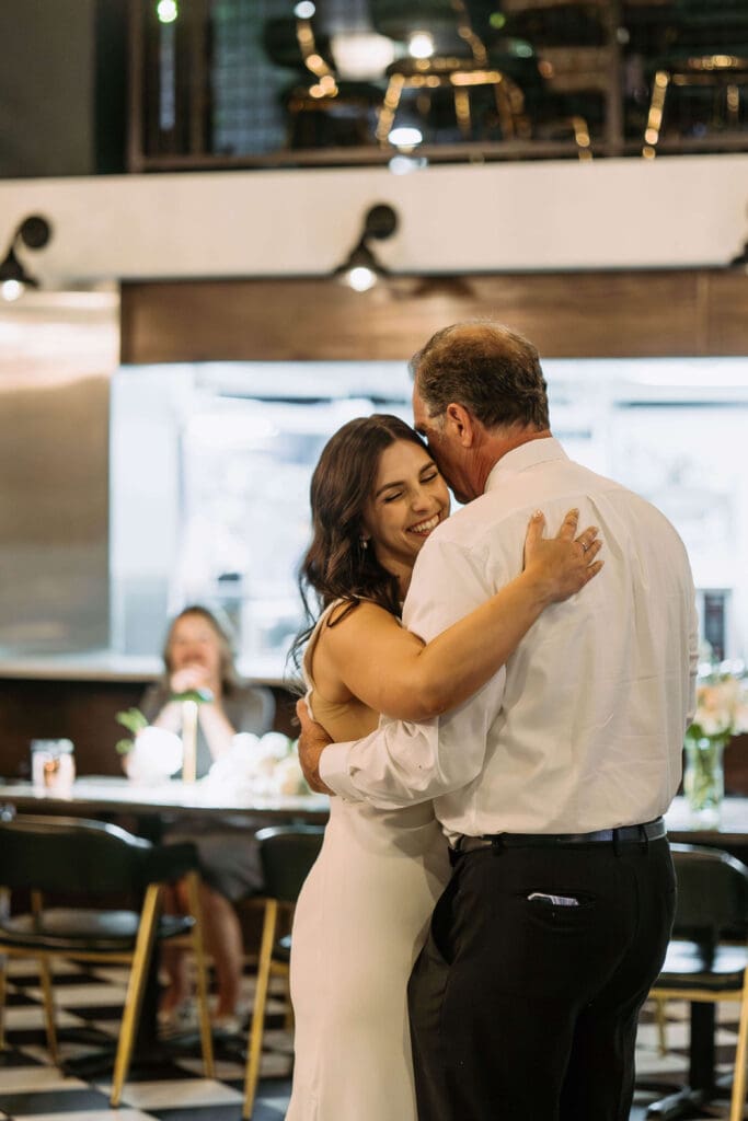 bride dances with dad at small wedding reception after mountain wedding
