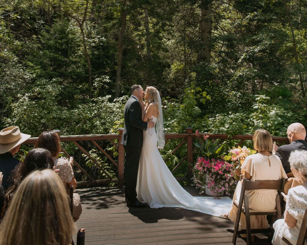 bride and groom first kiss in mountains